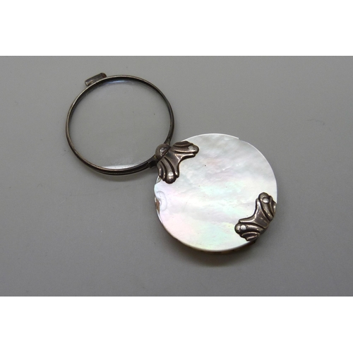 7070 - A white metal and mother of pearl eye glass, 3.9cm