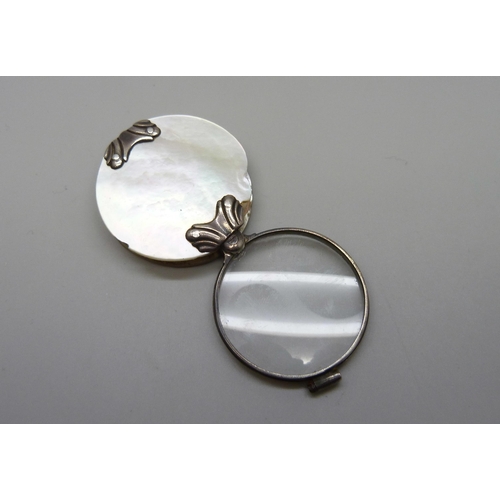 7070 - A white metal and mother of pearl eye glass, 3.9cm