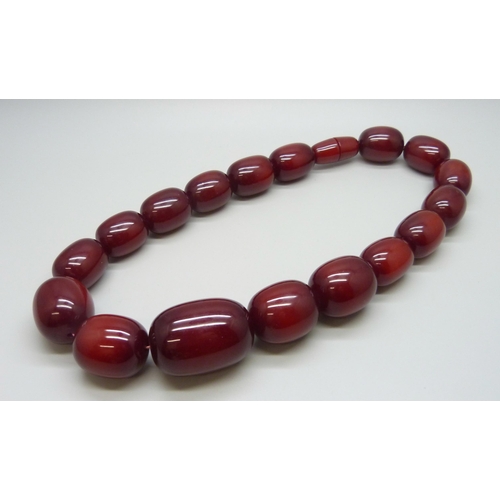 7079 - A very large cherry amber coloured bead necklace, largest bead approximately 4cm, 198g, 53cm