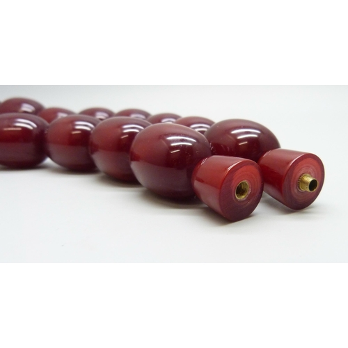 7079 - A very large cherry amber coloured bead necklace, largest bead approximately 4cm, 198g, 53cm