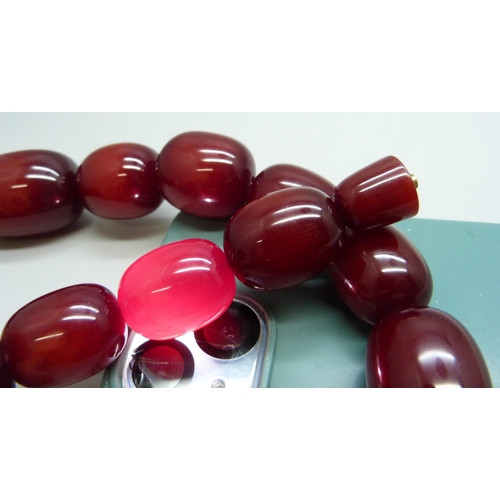 7079 - A very large cherry amber coloured bead necklace, largest bead approximately 4cm, 198g, 53cm