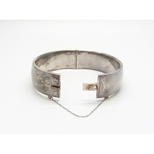 7099 - An engraved silver bangle, 44g, 6 x 5.5cm