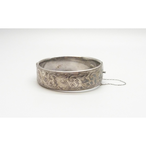 7099 - An engraved silver bangle, 44g, 6 x 5.5cm