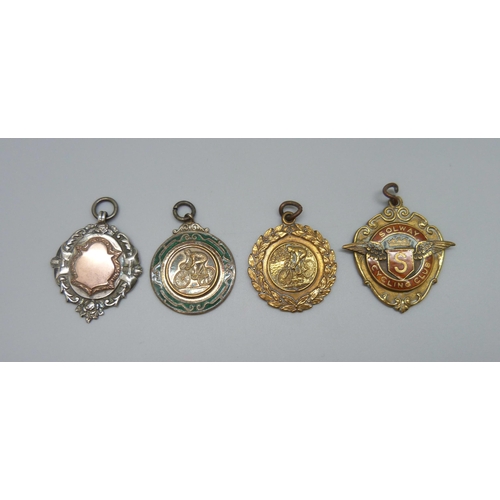 7103 - A silver fob with applied yellow metal plaque, 10g, and three metal examples