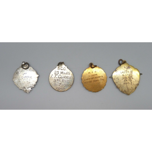 7103 - A silver fob with applied yellow metal plaque, 10g, and three metal examples