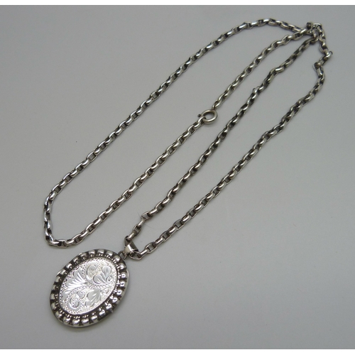 7104 - A Victorian style silver locket, 4.2cm including bail, on a silver long guard chain, 28g total, 73.5... 