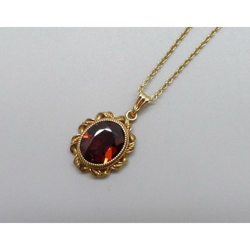 7105 - A 14k gold and garnet pendant, 2cm including bail, on a 9ct chain, 40.5cm, 3g total