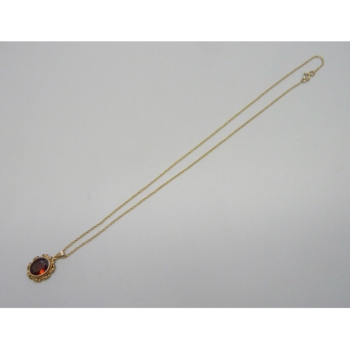 7105 - A 14k gold and garnet pendant, 2cm including bail, on a 9ct chain, 40.5cm, 3g total