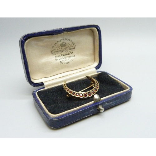 7107 - A 9ct gold crescent brooch set with garnets, 3g, 2.6cm