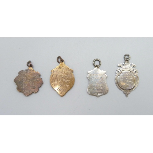 7110 - A silver fob with applied yellow metal plaque, another silver fob,11g, and two metal fobs