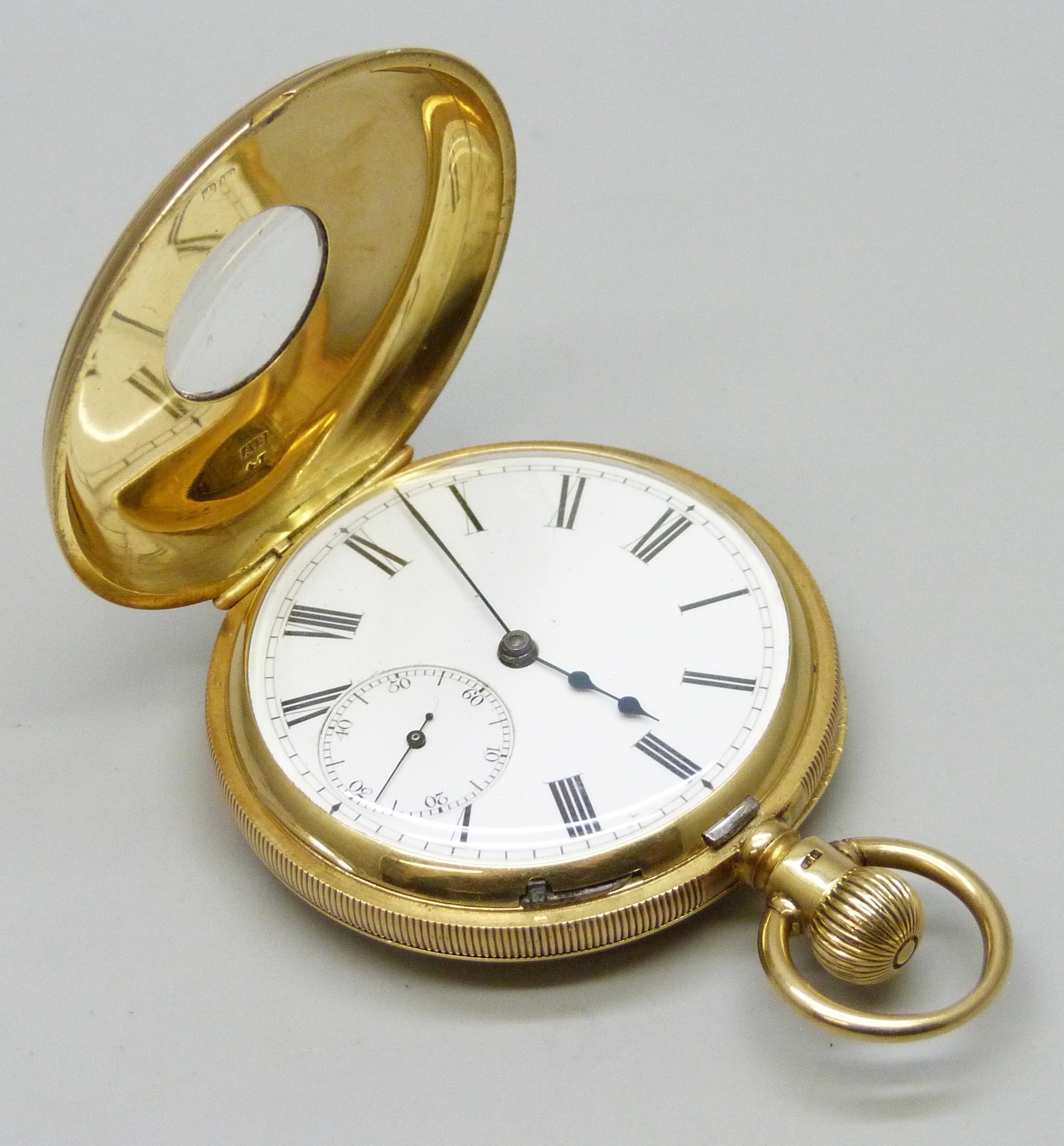 An 18ct gold half hunter pocket watch with engraved design and enamel ...