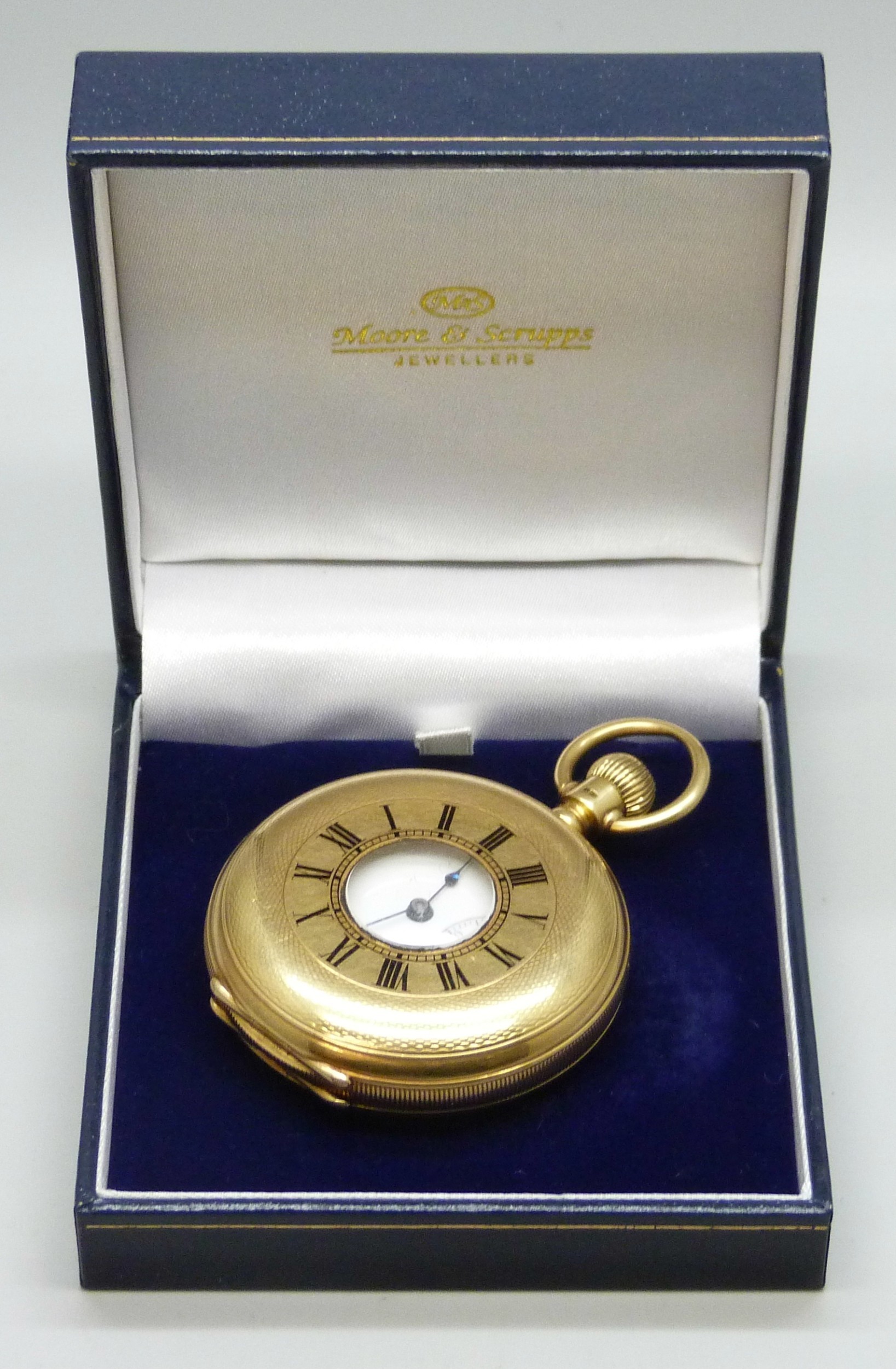 An 18ct gold half hunter pocket watch with engraved design and enamel ...