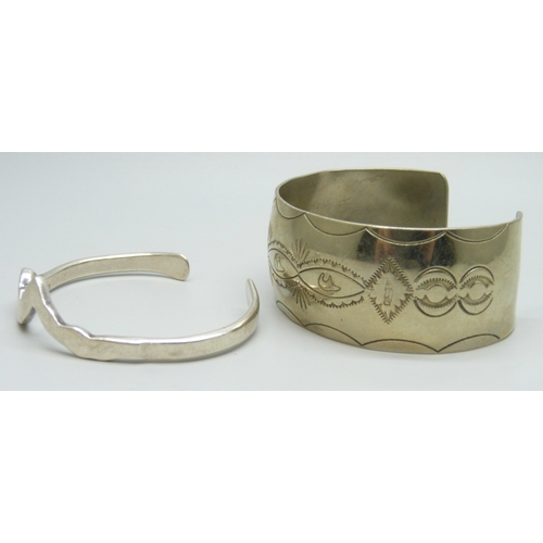 7021 - A Navajo style bangle with bear and feather decoration, marked C Sterling, 34g, and silver bangle in... 