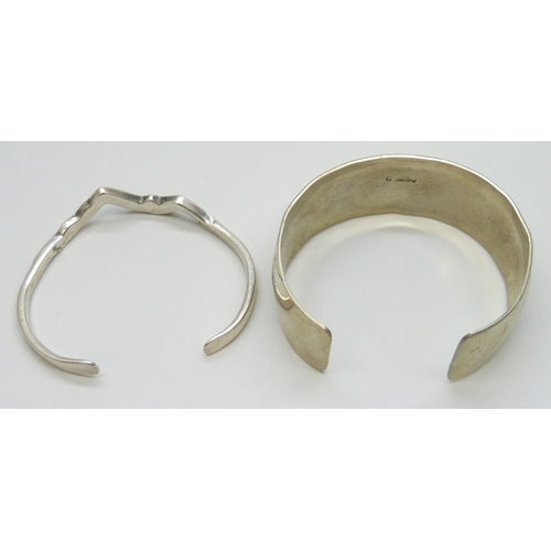 7021 - A Navajo style bangle with bear and feather decoration, marked C Sterling, 34g, and silver bangle in... 