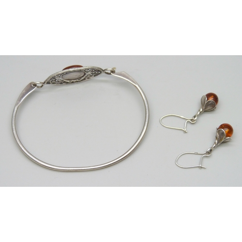 7041 - A silver and amber bangle, and a pair of silver and amber earrings, 11g total