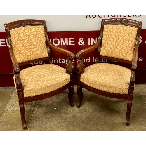 A pair of 19th Century French Empire style carved walnut fauteuil chairs