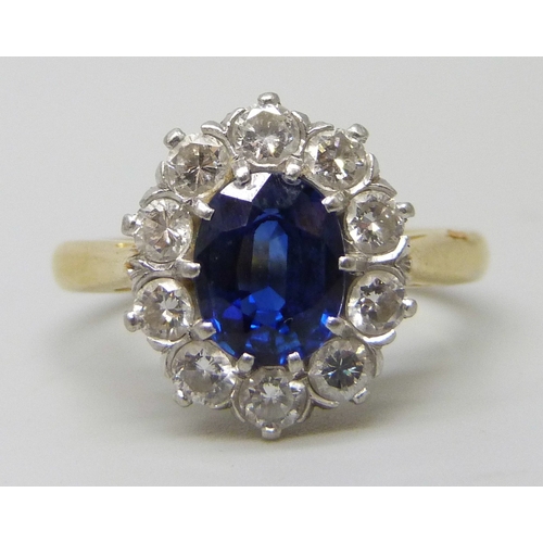 7283 - An 18ct yellow gold sapphire and diamond halo ring, 4.7g, M