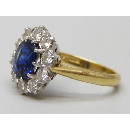 7283 - An 18ct yellow gold sapphire and diamond halo ring, 4.7g, M