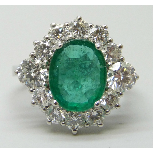 7180 - A platinum set emerald and diamond cluster ring, 6.1g, N/O