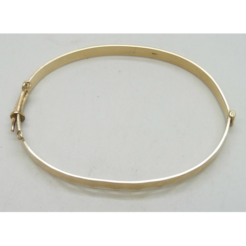 7080 - A 1/5th 9ct rolled gold bangle, 11.3g, 6.5 x 4.5cm