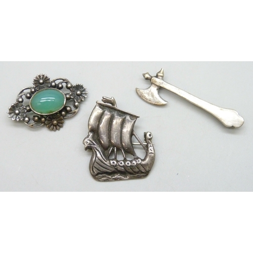 7106 - An Iona Scottish silver ship brooch, an Arts & Crafts silver and chrysoprase brooch, and a silver ax... 