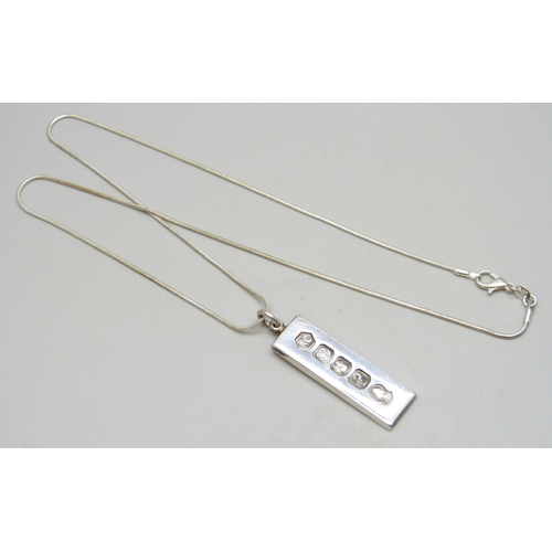 7125 - A silver ingot pendant, 16g, 5cm including bail, on a plated chain