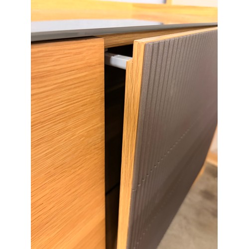 3002 - A Hobang oak 3 door sideboard with glass top