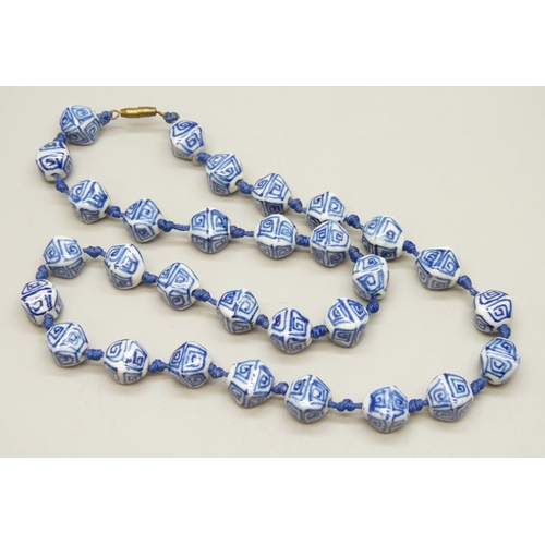 7028 - A vintage Chinese blue and white ceramic bead necklace, 51cm