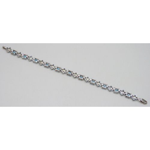 7046 - A silver set blue stone line bracelet, possibly topaz, 12g, 18.5cm