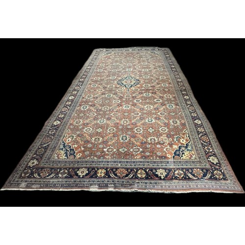 173 - A very large Eastern terracotta ground rug, 7m x 5ms