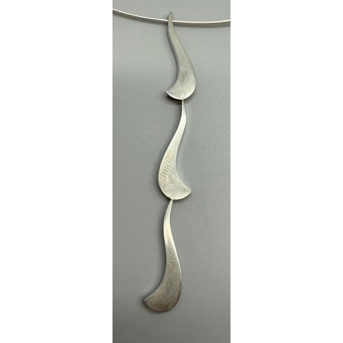7252 - Paul Spurgeon, a white metal Modernist style abstract design necklace pendant, tests as silver, on a... 