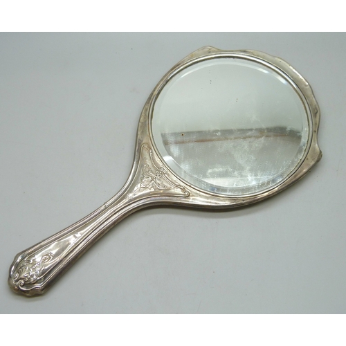 7032 - Three silver dressing table items - a hand mirror (a/f split), hair brush and clothes brush, 510g to... 