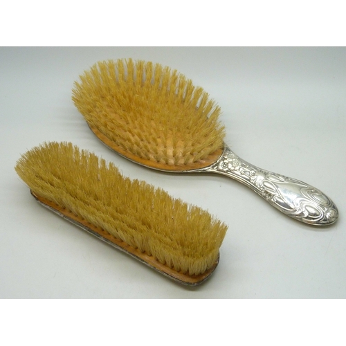 7032 - Three silver dressing table items - a hand mirror (a/f split), hair brush and clothes brush, 510g to... 