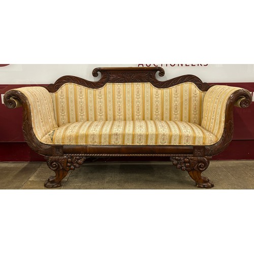 91 - A Regency carved mahogany and fabric upholstered scroll arm settee