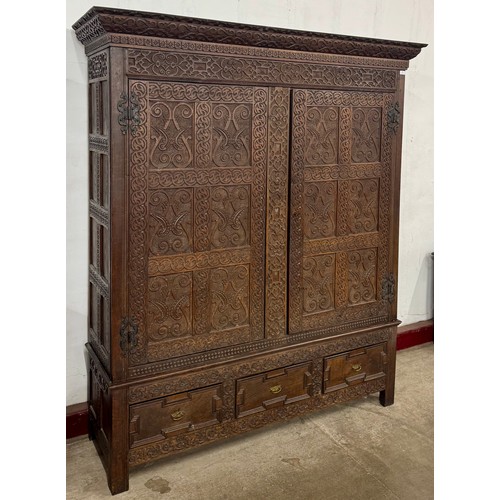 84 - A George III extensively carved oak two door tack cupboard