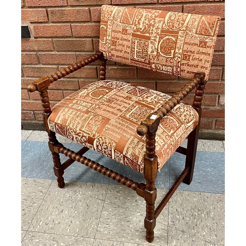 107 - An early 20th Century Elizabethan Revival oak bobbin turned and fabric upholstered chair