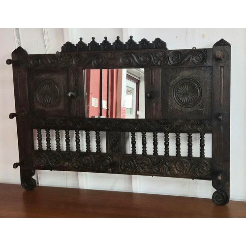 110 - A Victorian Jacobean Revival carved oak hall mirror/coat rack