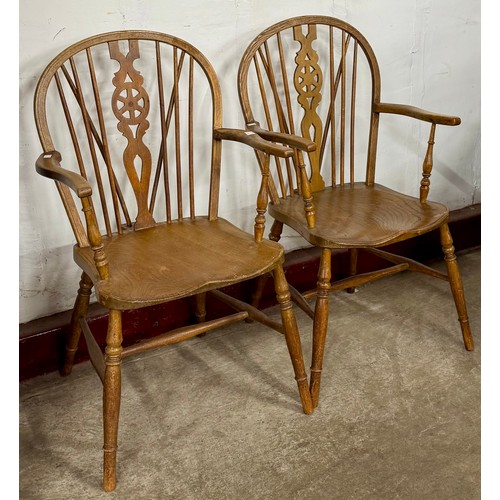 115 - A pair of early 20th Century elm and beech wheelback kitchen chairs