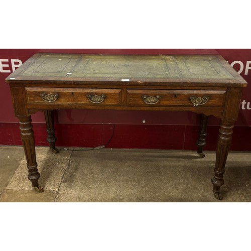 130 - An Edward VII oak and green leather topped two drawer writing table