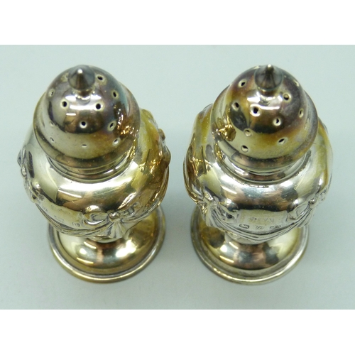 7130 - A Victorian silver salt and pepper with swag and bow design, Birmingham 1899 and 1900, 34g, 7.2cm, c... 