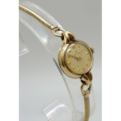 7148 - A lady's 9ct gold Omega wristwatch on a 9ct gold strap, 14.8g, 20mm including crown