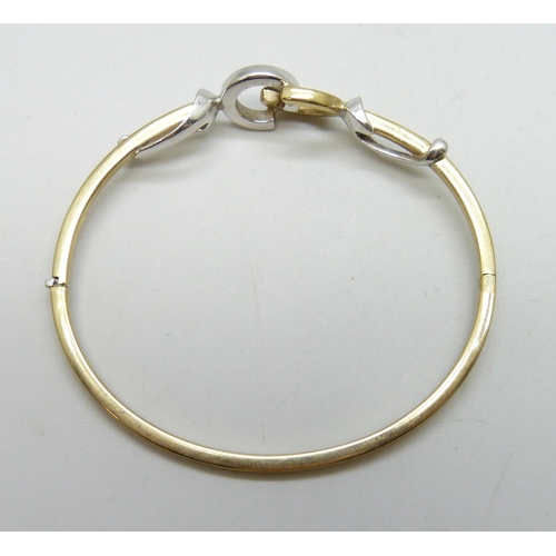 7001 - A 9ct white and yellow gold bangle with interlocking loop design, 7.4g, 6 x 5cm