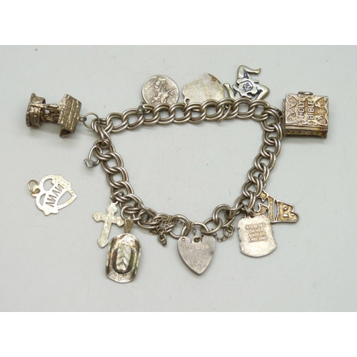 7008 - A silver charm bracelet with silver and white metal charms, 32g, and a yellow metal charm, 0.3g