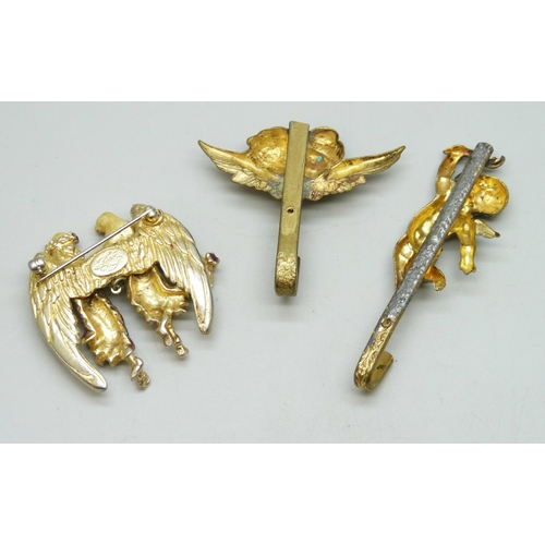 7025 - A Kirks Folly angel brooch, and two cherub hooks, largest 6.5cm