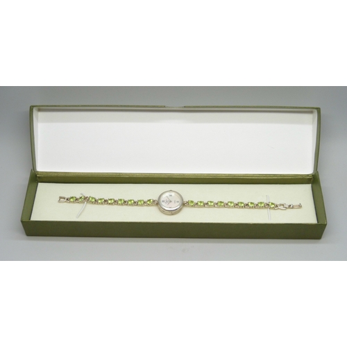 7058 - A silver and peridot lady's wristwatch, 24g, 19cm