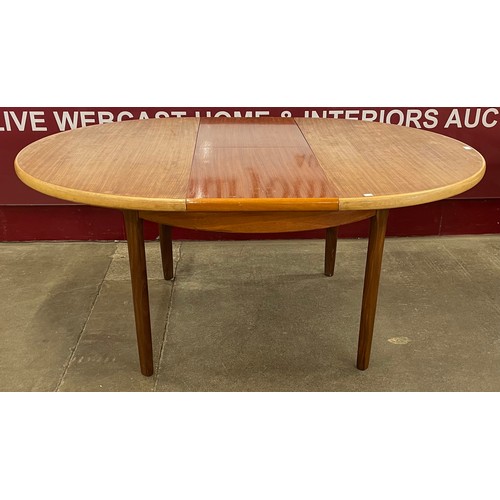 32 - A teak circular extending dining table
