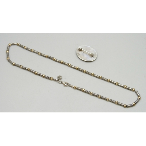 7015 - A silver and gilt necklace, 17g, and a white metal and synthetic opal brooch, 3.1cm
