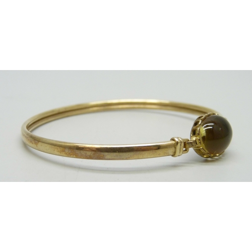 7054 - A 9ct gold bangle, the cabochon a/f, 4.9g, 5.8 x 5.1cm