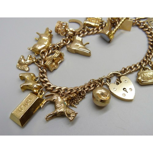 7237D - A 9ct gold curb chain bracelet with padlock clasp, with a collection of 9ct gold charms, a 15ct gold... 