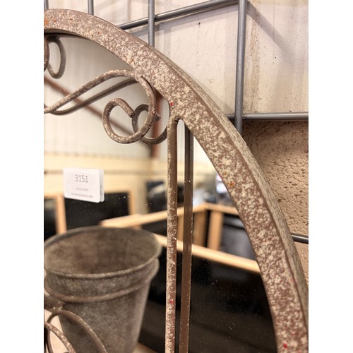 3100 - A distressed metal wall mirror features an arched, vintage-style design equipped with three built-in... 
